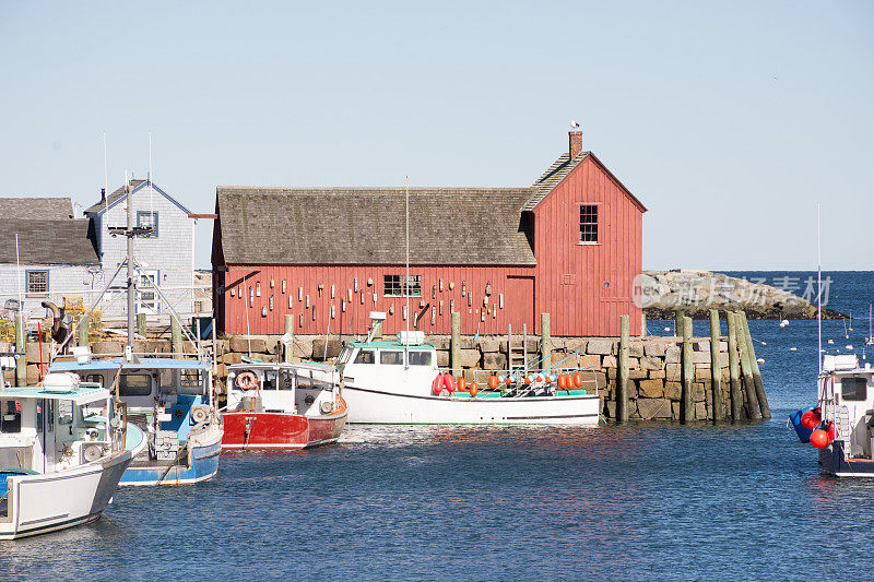 龙虾船在下午晚些时候的阳光停靠在Motif Number 1附近，布拉德利码头，罗克波特，马萨诸塞州。晴空万里。
